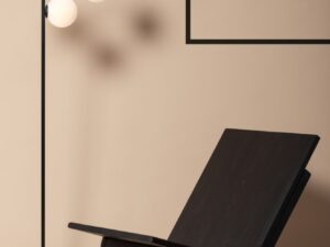 Miniaturka 2 - Czarna lampa podłogowa Andy obok fotela w nowoczesnym salonie
