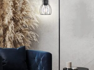Miniaturka 1 - Lampa podłogowa Evatena z czarnym ażurowym kloszem obok granatowej sofy w salonie