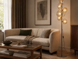 Miniaturka 3 - Ciemnobrązowa lampa podłogowa Nebia z sześcioma kloszami w odcieniu koniakowym przy sofie w salonie