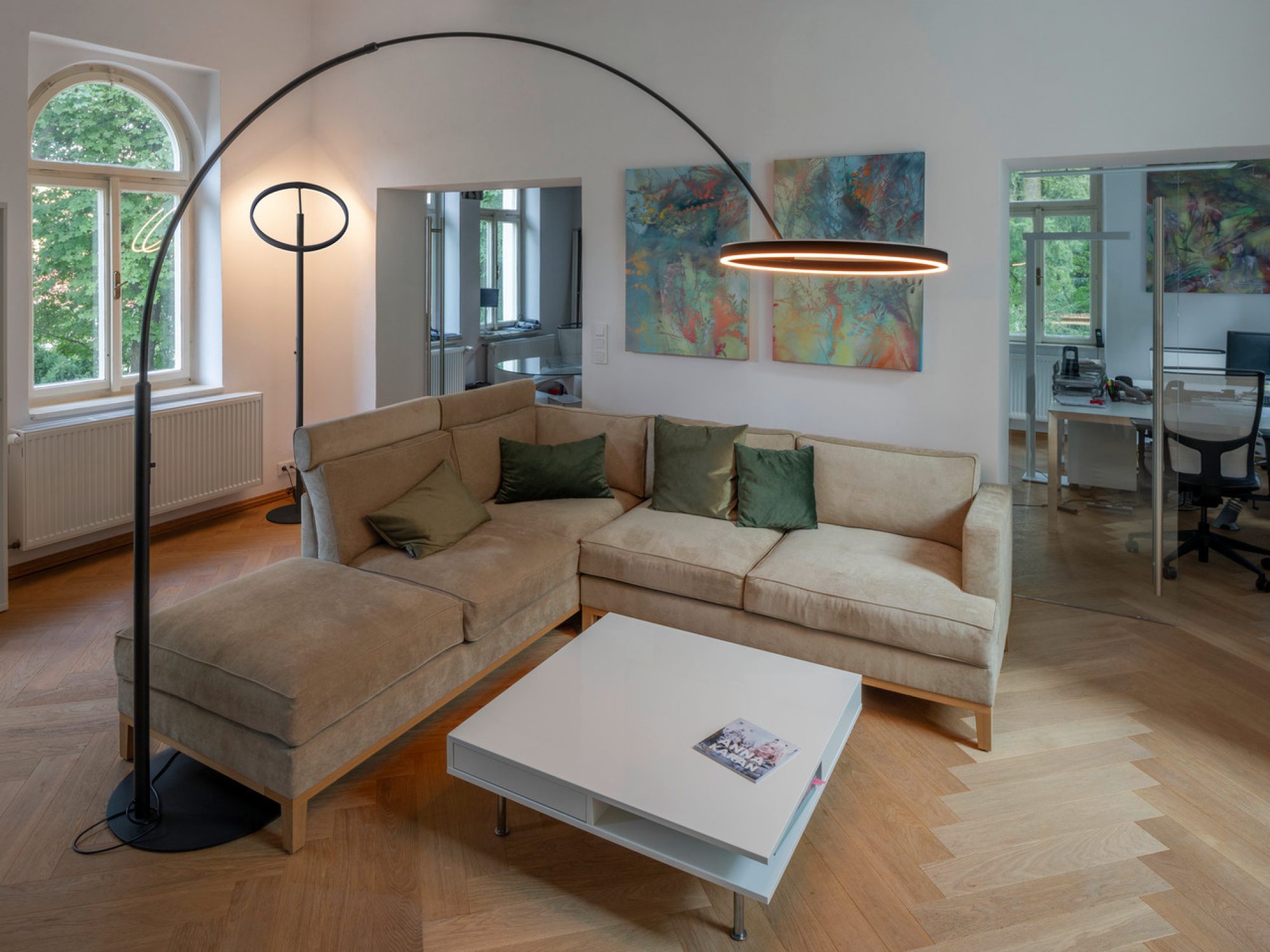 Czarna lampa One Bow FL nad sofą w salonie