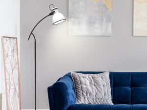 Miniaturka 1 - Lampa podłogowa Veledira z białym kloszem stojąca obok niebieskiej sofy