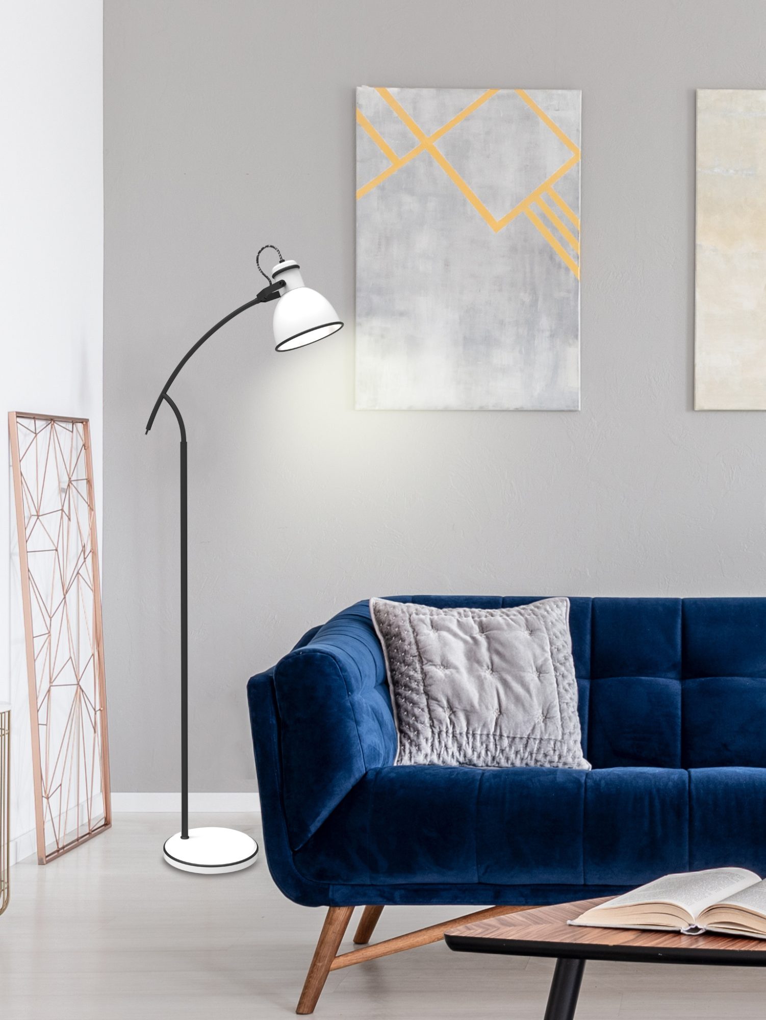 Lampa podłogowa Veledira z białym kloszem stojąca obok niebieskiej sofy