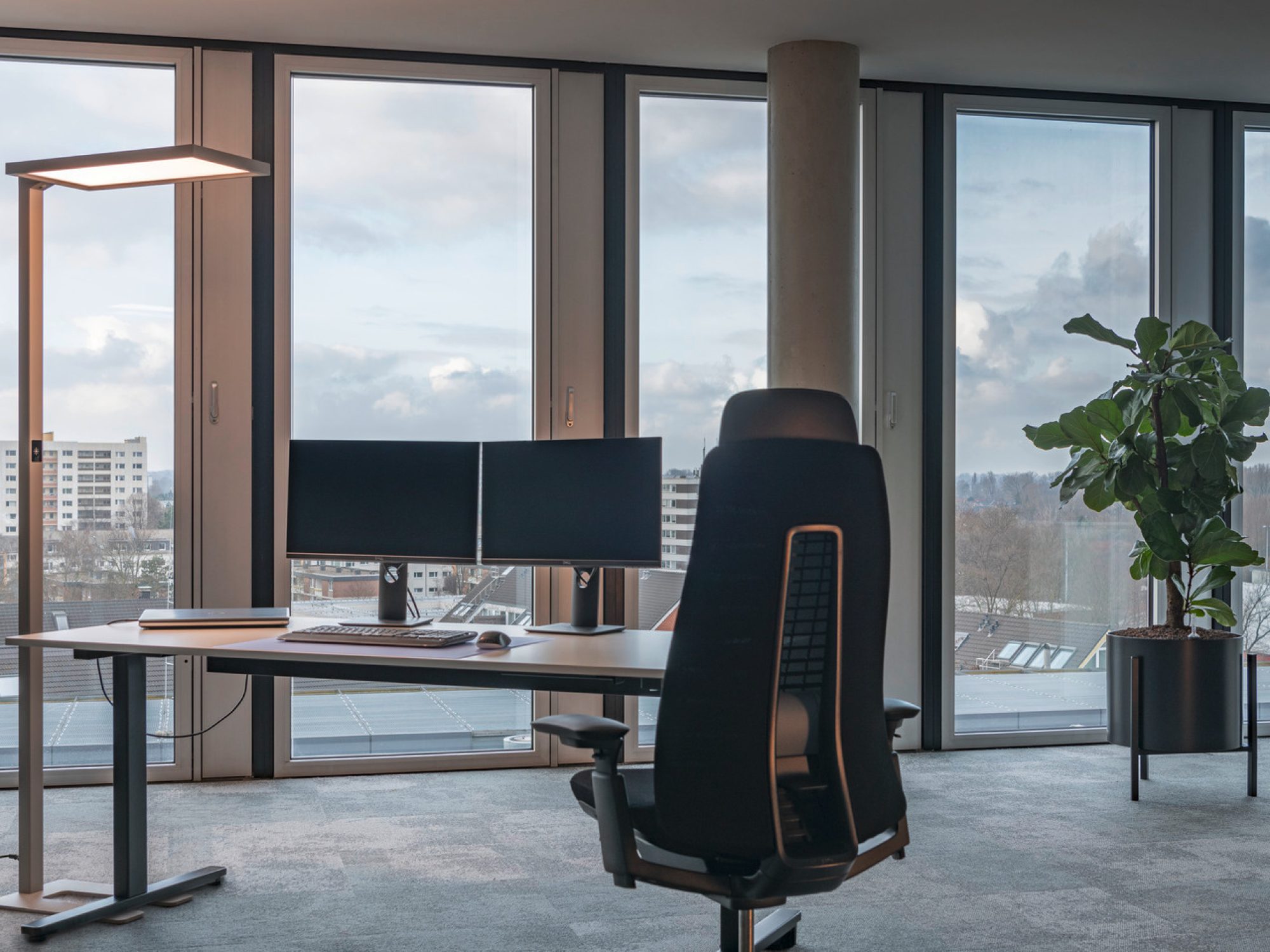 Srebrna lampa podłogowa Worklight LED obok biurka i okna