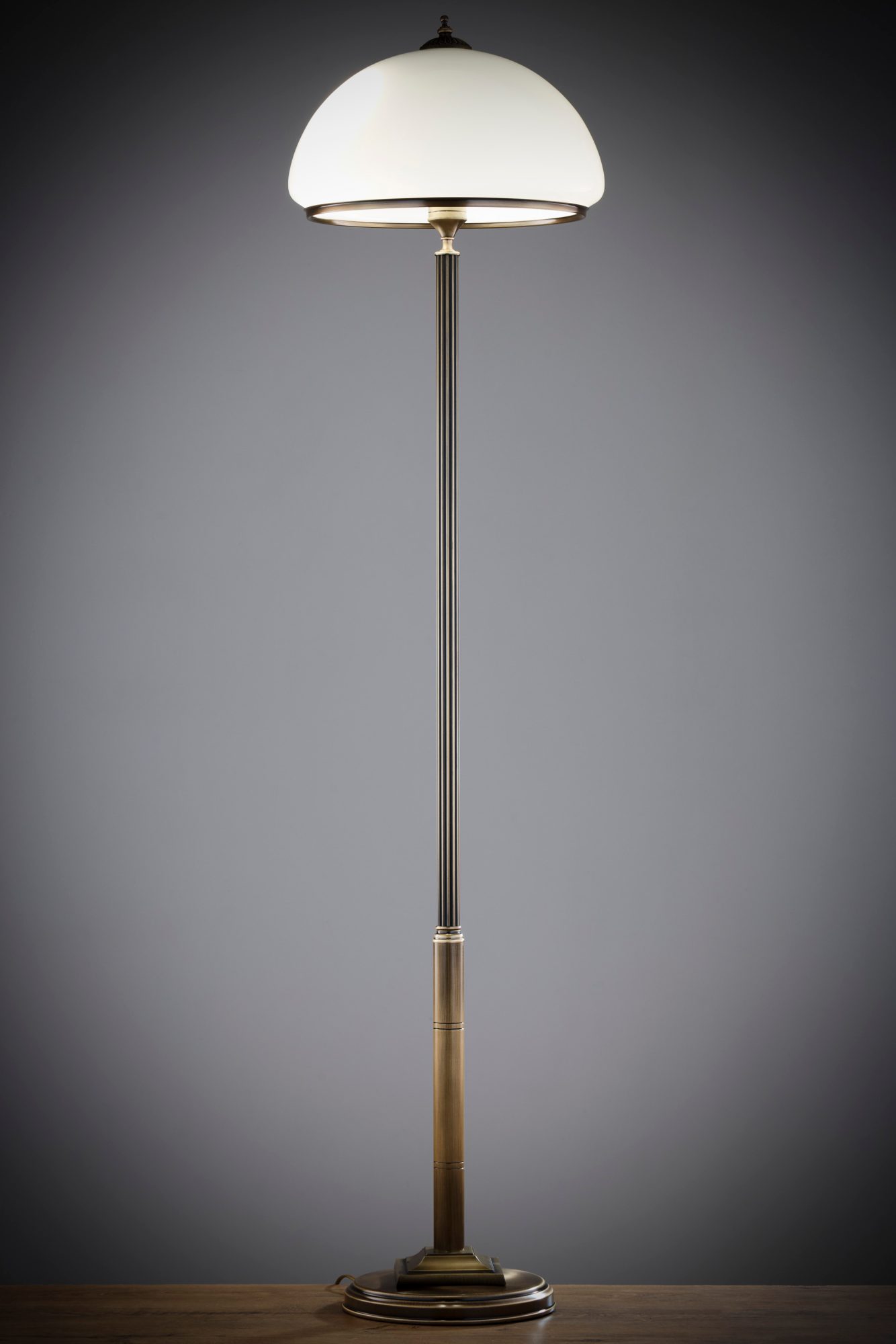 Lampa podłogowa Zeus z rozświetlonym półkulistym kloszem na ciemnym tle