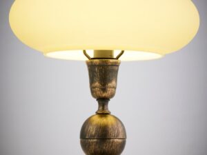Miniaturka 3 - Detal stalowo-szklanej lampy stołowej Bolero w złotej patynie