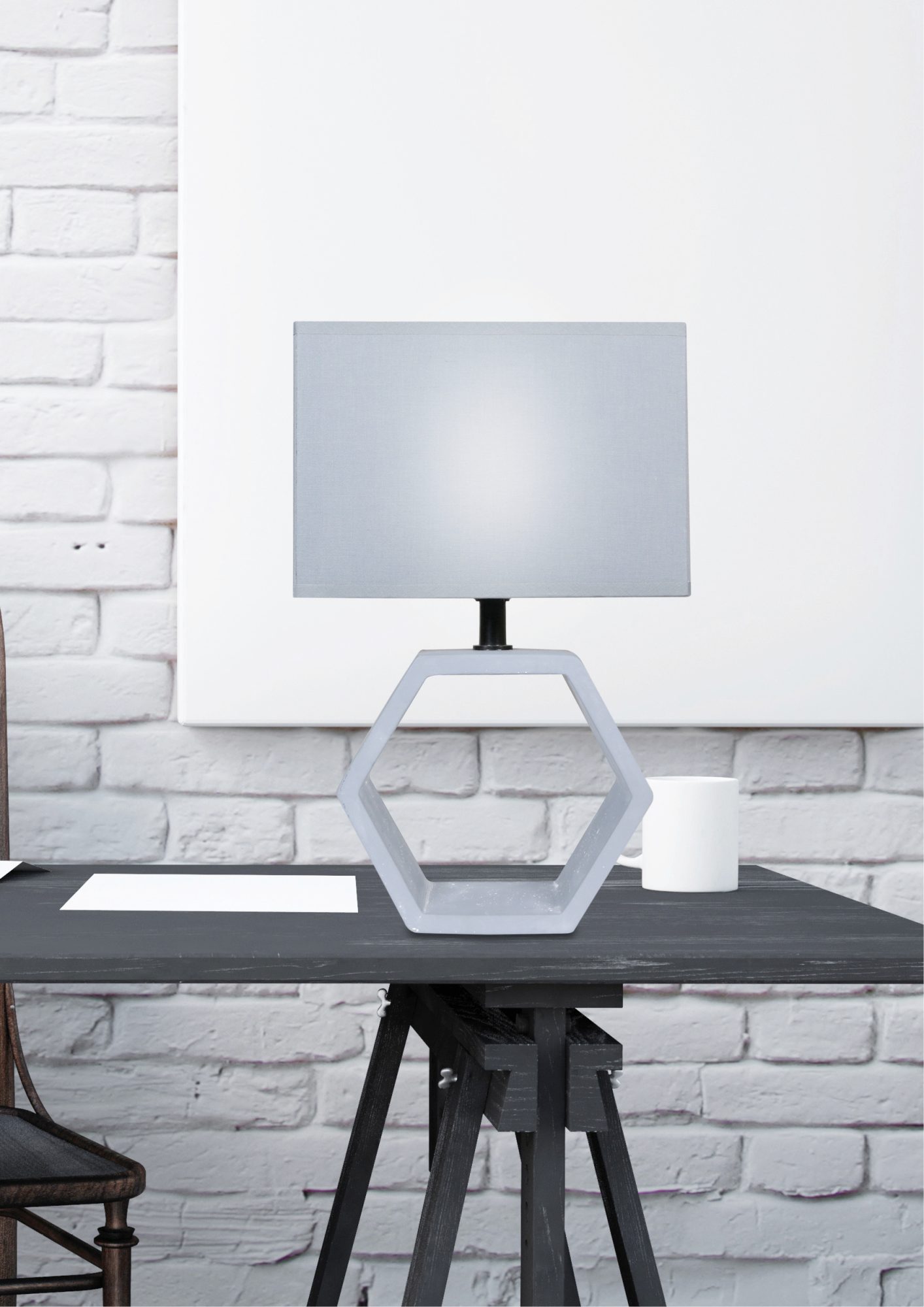 Lampa stołowa Gilavira grafitowa na biurku przy jasnej ceglanej ścianie