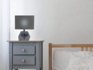Miniaturka 1 - Lampa stołowa Mirivona z ciemnoszarym abażurem ustawiona na stoliku nocnym w sypialni