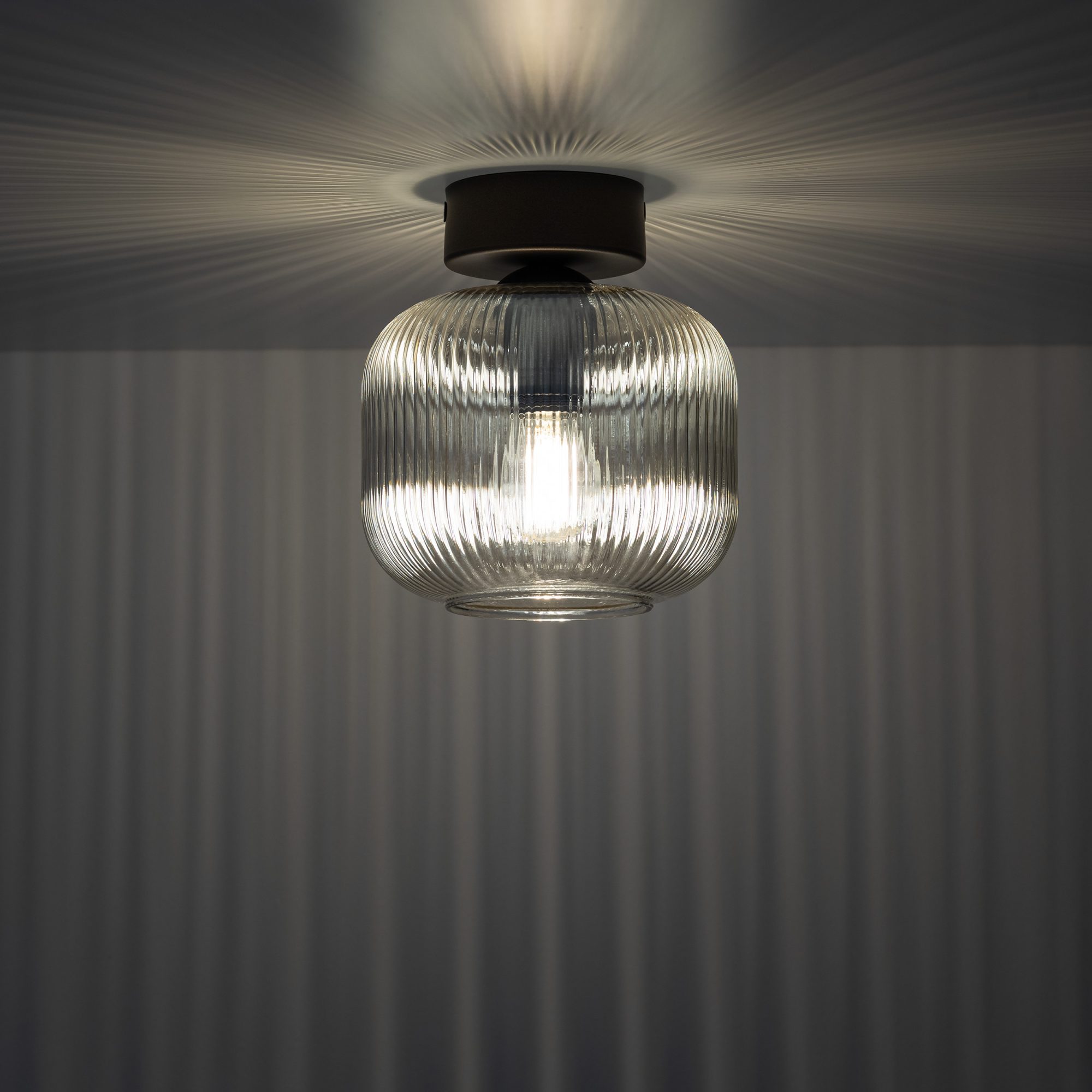 Lampa sufitowa Salvia jednopunktowa z zapaloną żarówką za ryflowanym szkłem