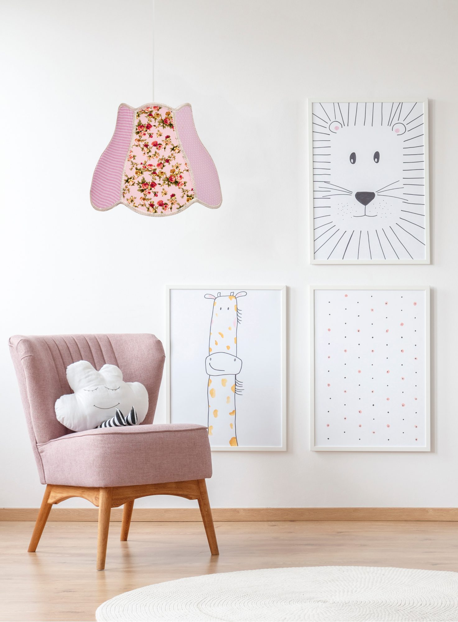 Różowa lampa Alotora w pokoju dziecięcym z różowym fotelem i ilustracjami