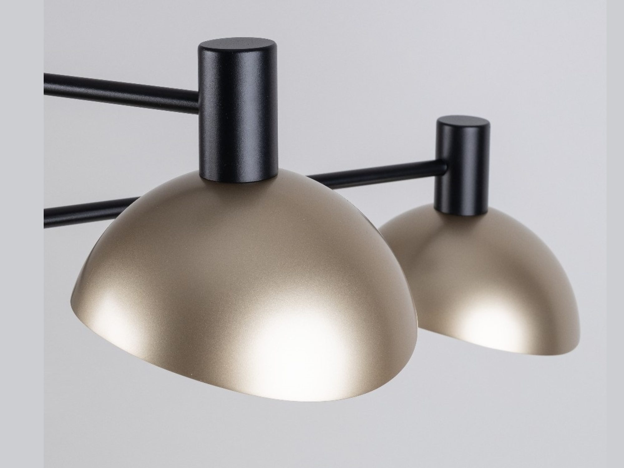 Zbliżenie na złote klosze i czarne ramiona lampy wiszącej Artis 3