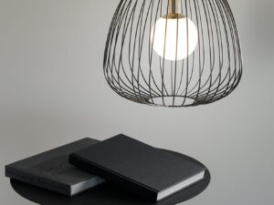 Miniaturka 7 - Lampa Bell 1 M czarno-złota wisząca nad czarnym stolikiem w nowoczesnym wnętrzu