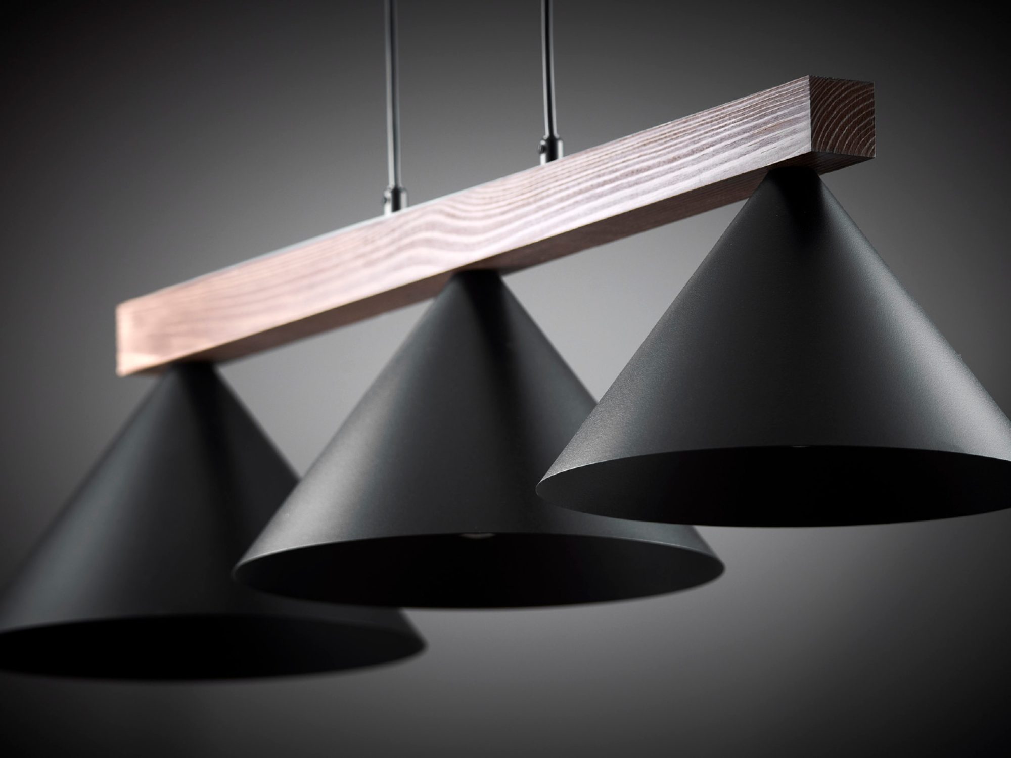 Lampa wisząca Deco 3 z ciemną drewnianą belką, trzy czarne klosze oświetlone od spodu