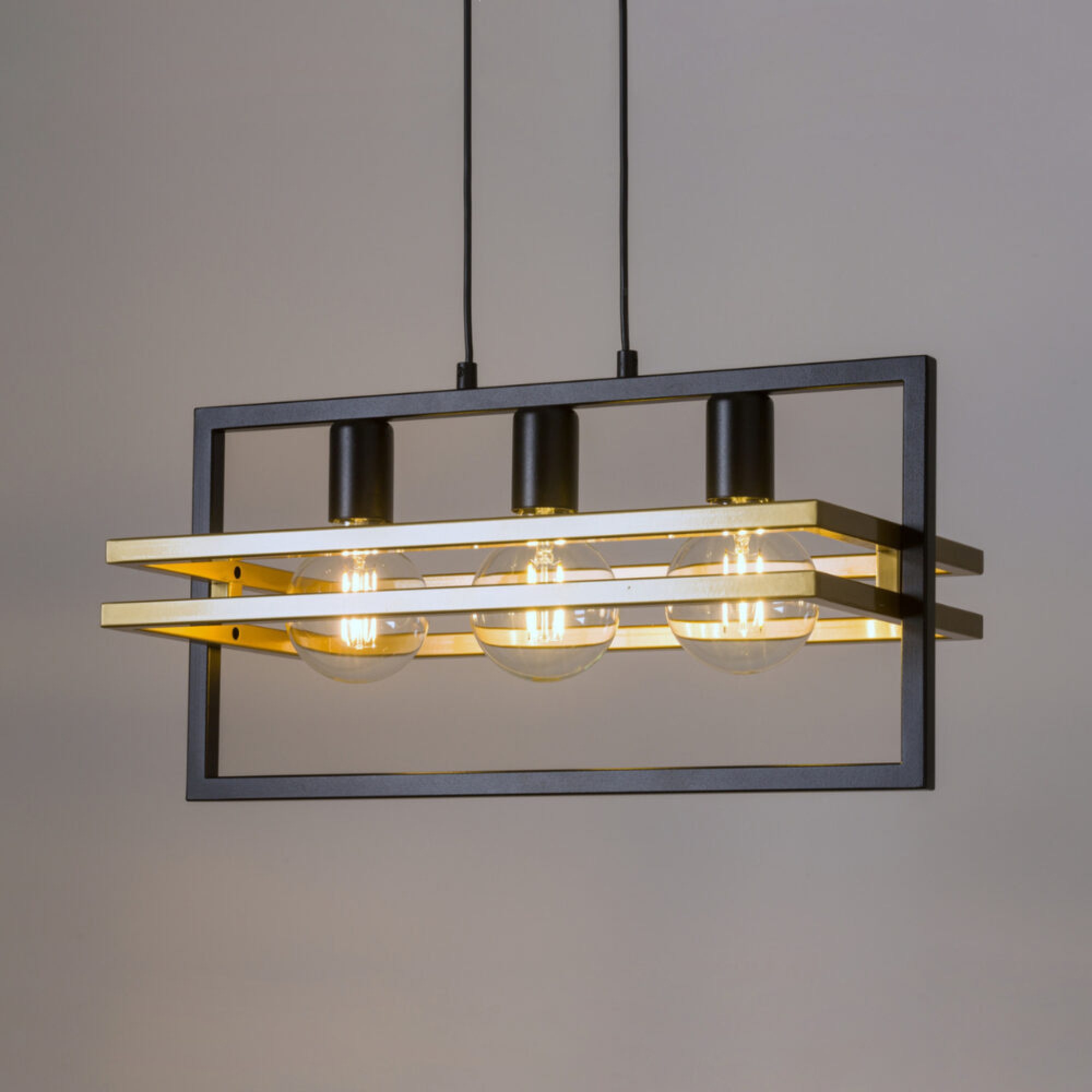 Lampa wisząca Merci 3 czarno-złota w przestrzeni mieszkalnej