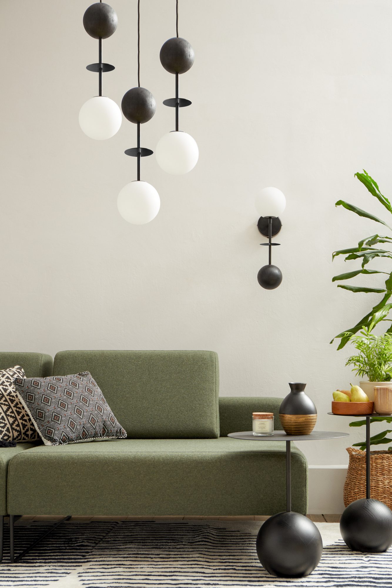 Lampa wisząca OIO A 3P czarna w aranżacji salonu z zieloną sofą