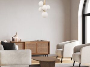 Miniaturka 3 - Lampa wisząca Perla 5 złoty beż zawieszona w salonie z jasnymi fotelami i drewnianą komodą