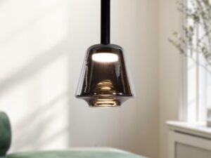 Miniaturka 1 - Lampa wisząca Rominia z dymionym szklanym kloszem i włączonym światłem nad sofą