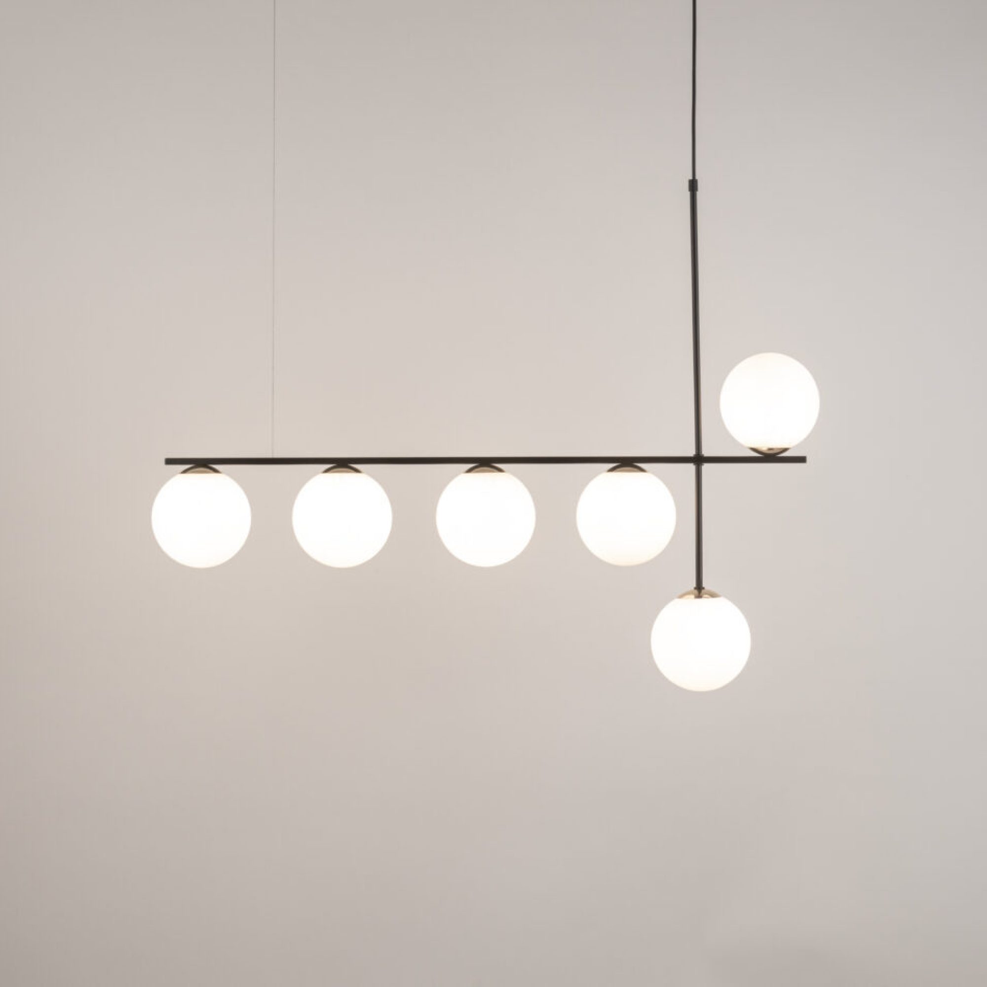 Lampa wisząca Silia 6 – sześć świecących białych kul na czarnej metalowej konstrukcji