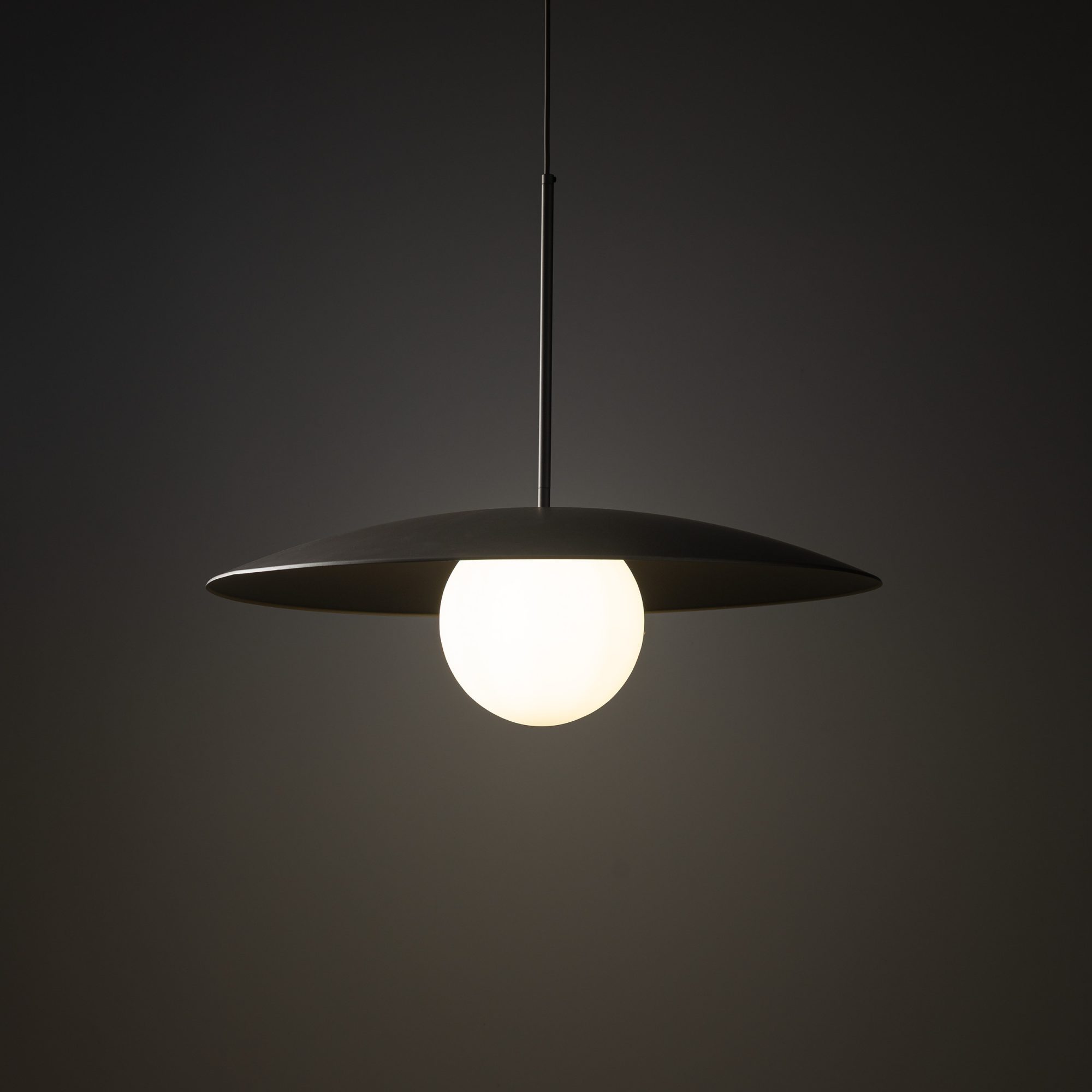 Lampa Slate z ciemnym kloszem i podświetloną białą kulą w aranżacji