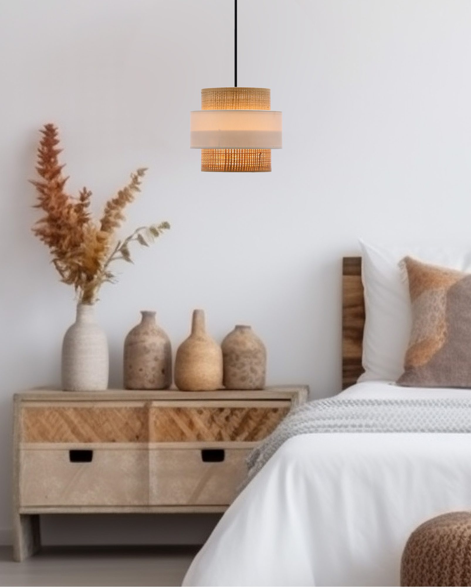 Lampa wisząca z kremowym rattanem i białą opaską nad stolikiem przy łóżku w sypialni
