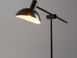 Miniaturka 4 - Lampka stołowa Artis czarna, zapalona, na tle szarej ściany