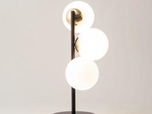 Miniaturka 1 - Lampka stołowa Piano czarno-złota z trzema świecącymi białymi kulami na jasnym tle