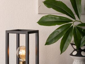 Miniaturka 2 - Czarno-złota lampka stołowa Vigo w aranżacji wnętrza z zieloną rośliną obok