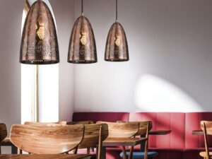 Miniaturka 1 - Miedziane lampy wiszące Arotio nad drewnianymi stolikami w aranżacji wnętrza