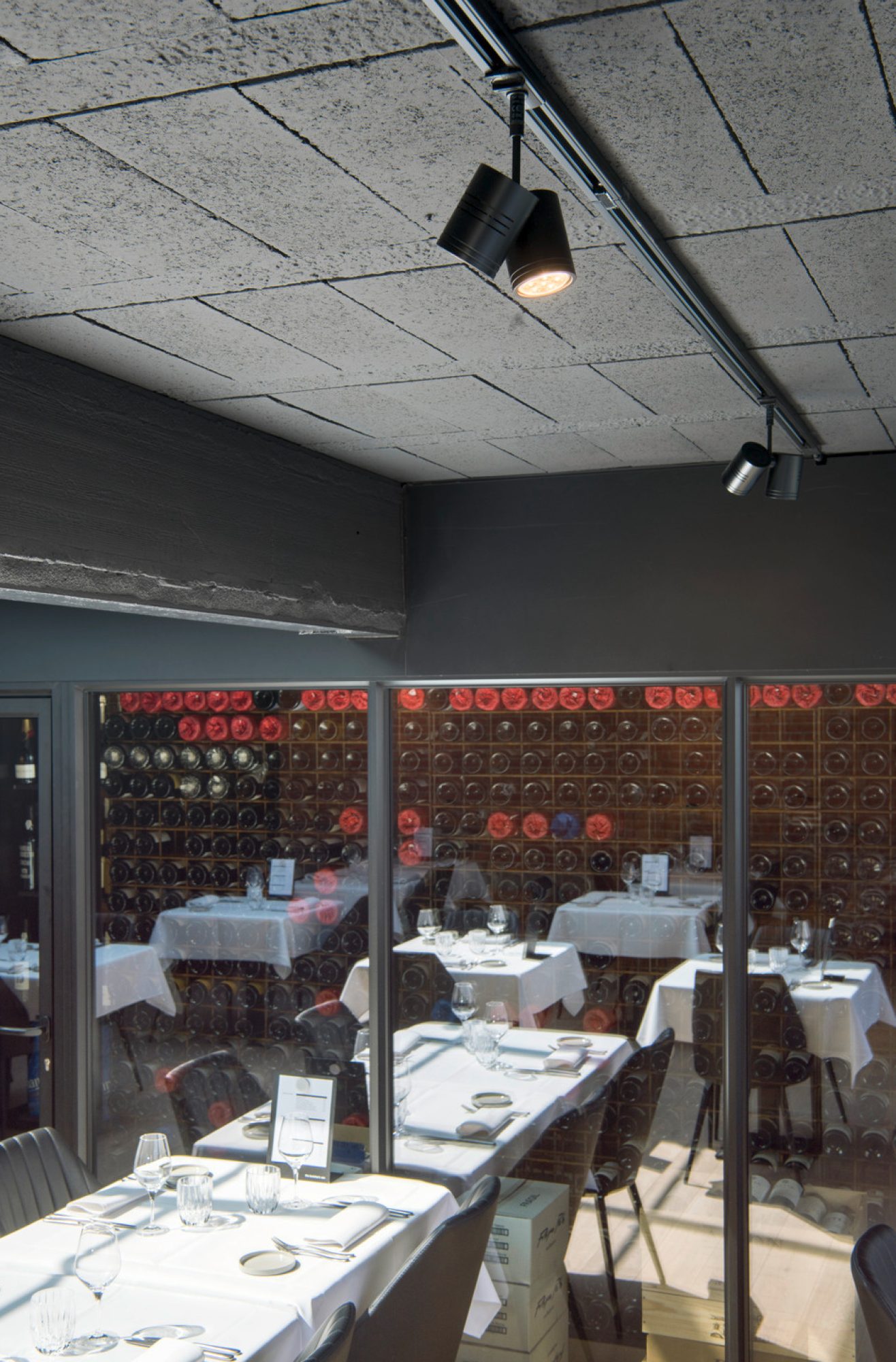 Czarny dwugłowicowy reflektor Bima 2 na szynie w aranżacji wnętrza restauracji