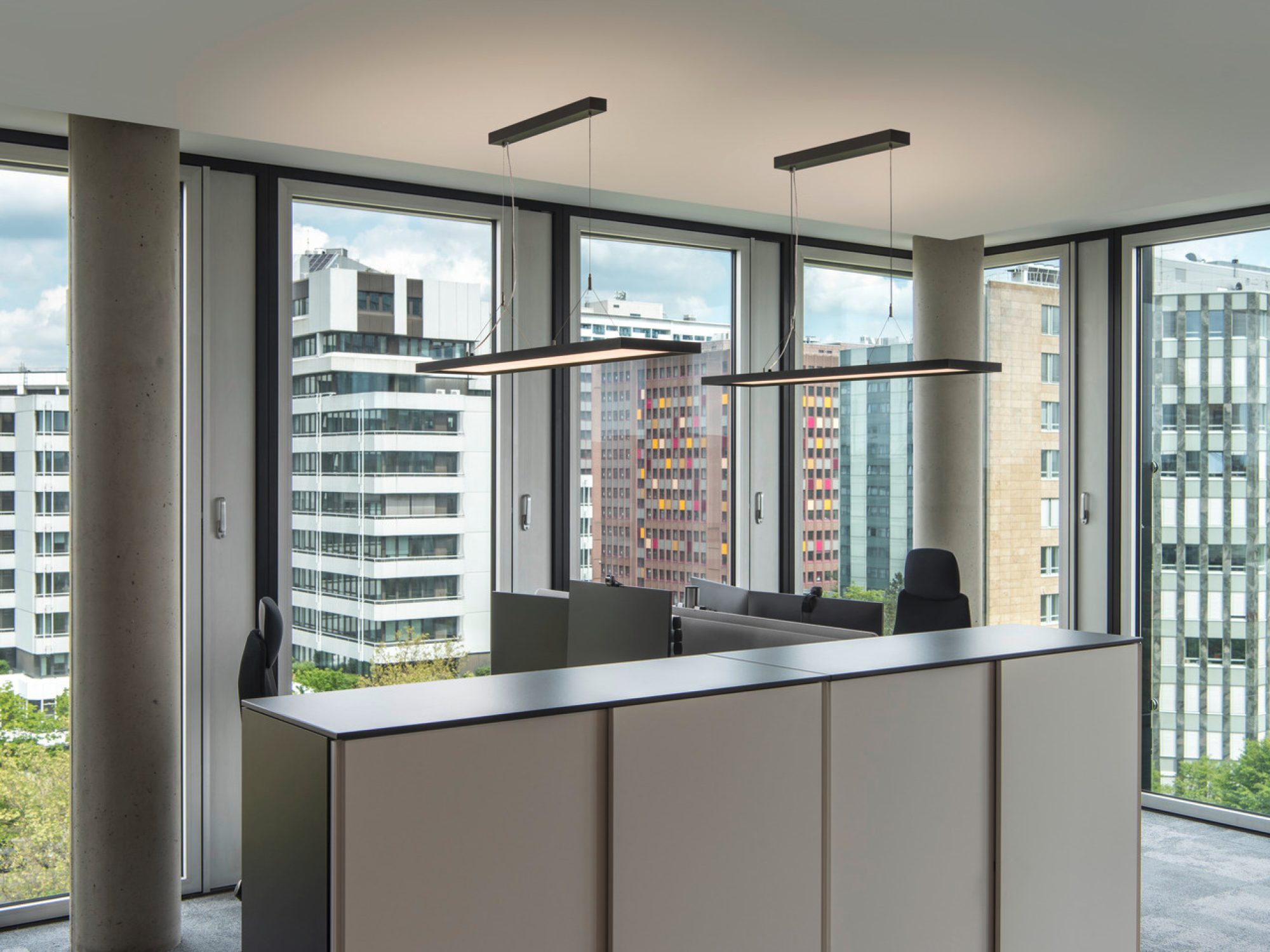 Czarne lampy Worklight nad recepcją w nowoczesnym biurze